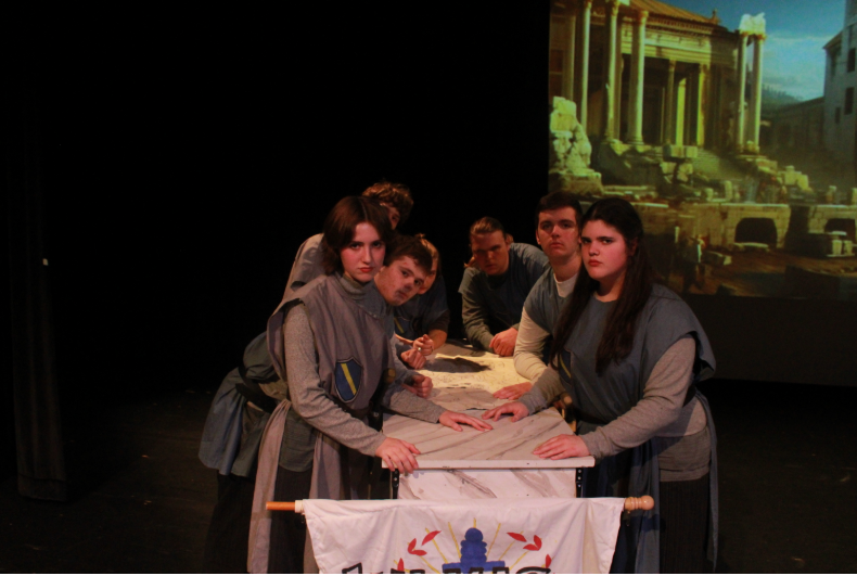 Left Side: Ophelia Brady (11), Caleb Barnes (11), Raphael Alexander-Friis (11), & Andrew Olson (12). 
Right Side: Gillian  Nothnagel (11), Gabe Coleta (11), & Andrew Rose (12) Figuring out a Battle Plan to take down Caesar.