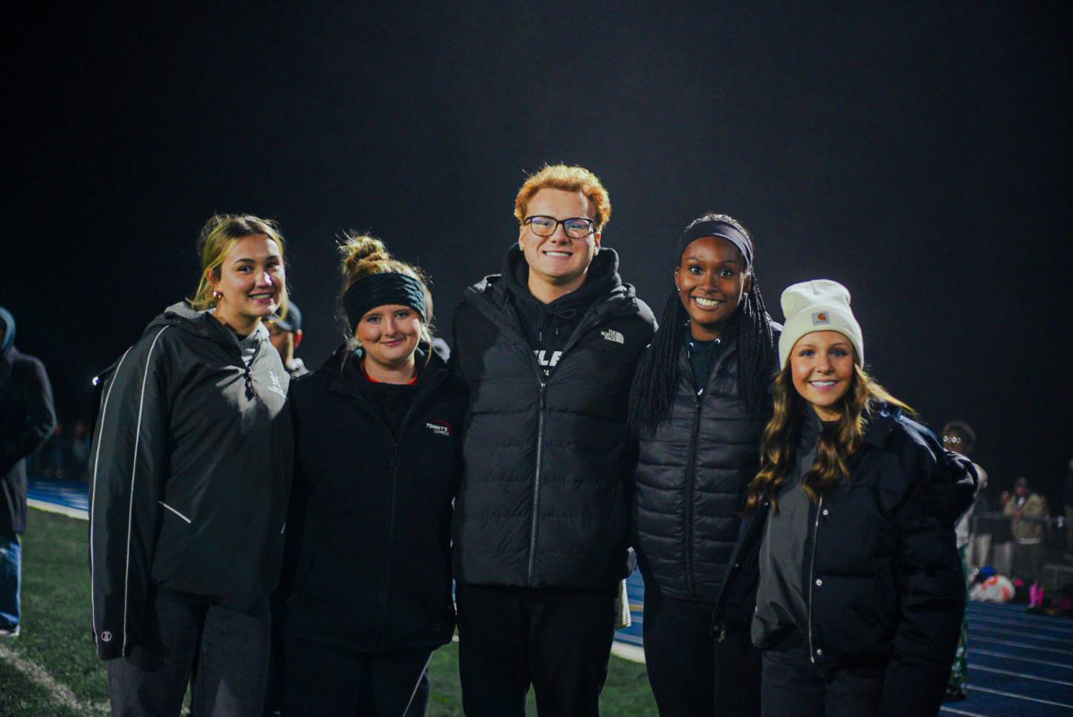 Nela Marceta (11), Izabella Jardine (12), Ayden Goodwin, Jada Roussel (12), and Bella Luetke (11) in a group photo at a late night football game.
