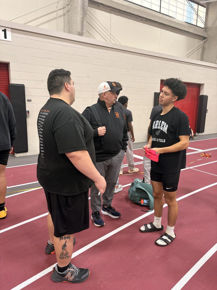 Coach John Terry and coach Michael Oliveri talking to Austin Wagaman (11) after he got done with his event.